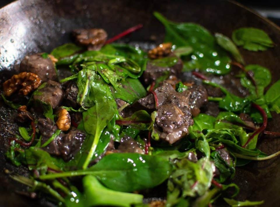 Frying porcini mushrooms and greens